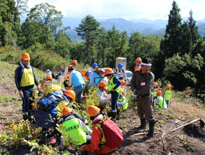 飯豊町で苗木を植樹する参加者